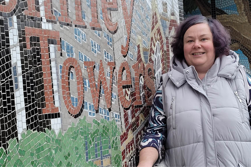 A block rep standing beside the Shirley Towers mosaic