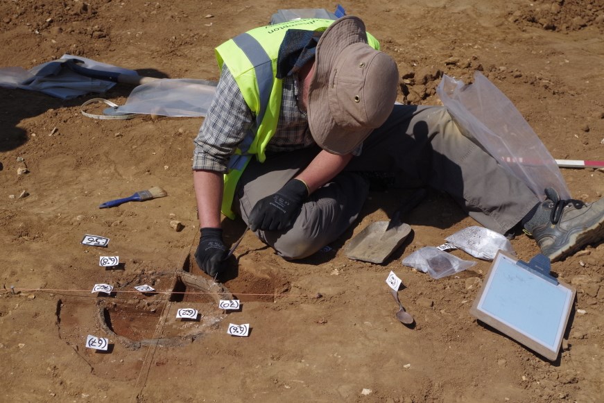 Archaeologist excavating a cremation