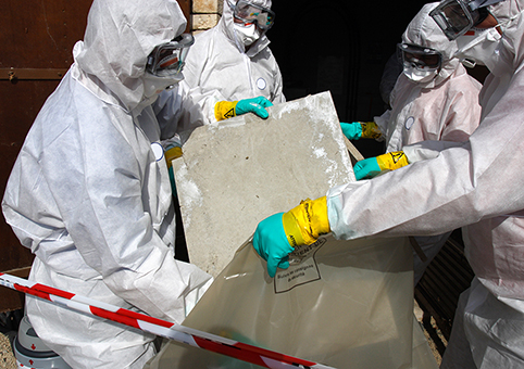People in protective clothing carefully disposing of asbestos