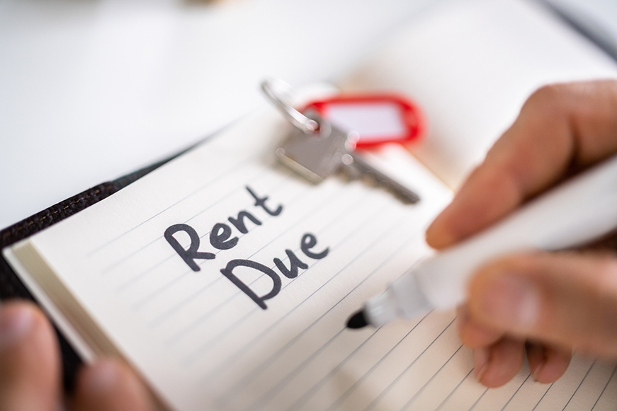 A note book showing "Rent Due" written in large, bold letters. House keys sit beside the text