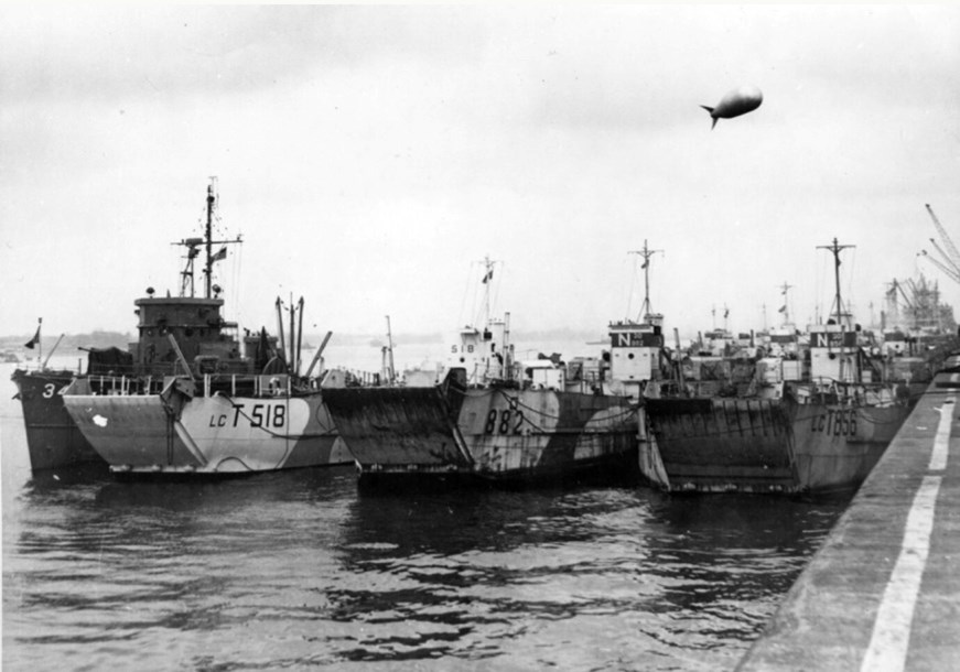 Three D-Day landing craft with a barrage balloon above them