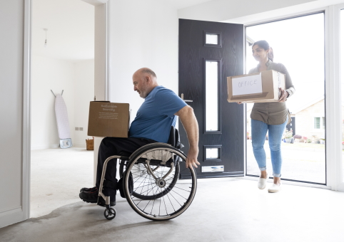 Man in wheelchair moving in to a new home