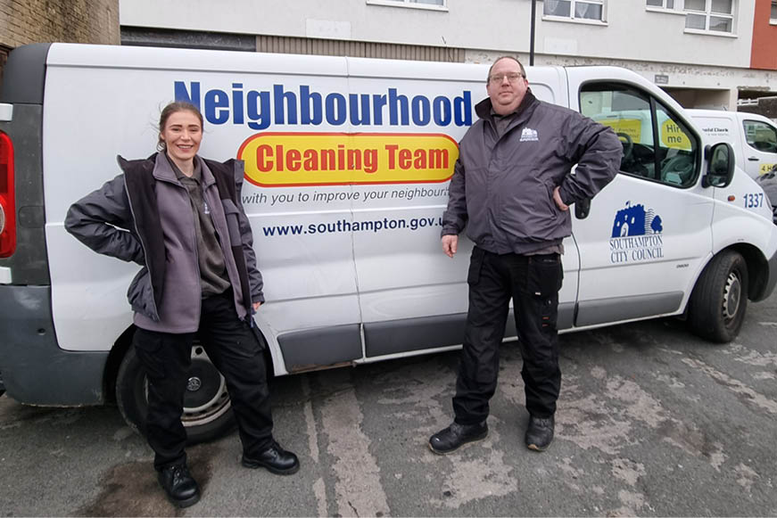 Two cleaning supervisors posing with a Neighbourhood Cleaning Team van