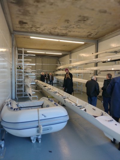 A number of people and boats in the new storage area