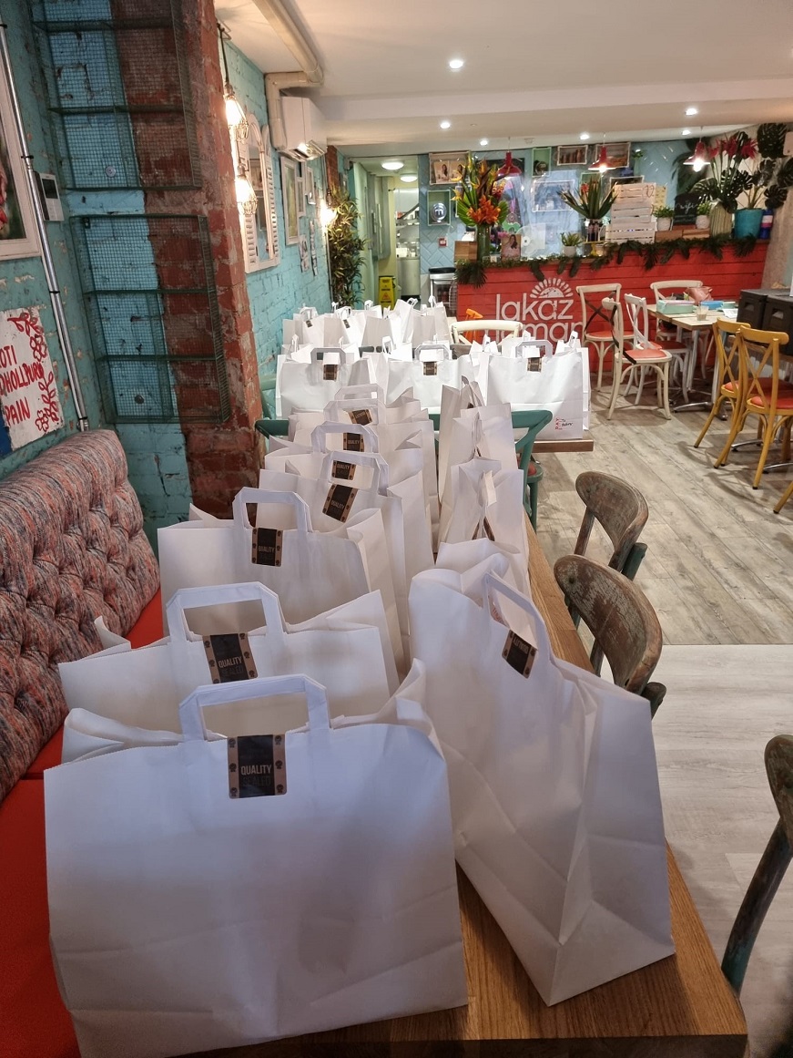 Several tables covered with food bags inside the Lakaz Maman restaurant