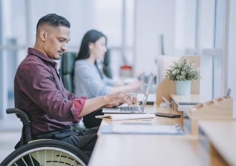 Man in wheelchair working at laptop