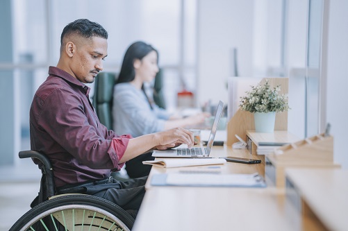 Man in wheelchair working at laptop