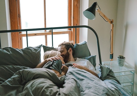 A couple cuddling in bed