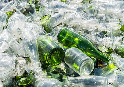 A pile of clear and green glass bottles