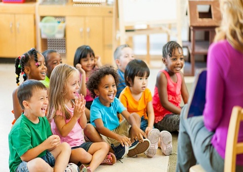 Children sitting on the floor with an adult reading