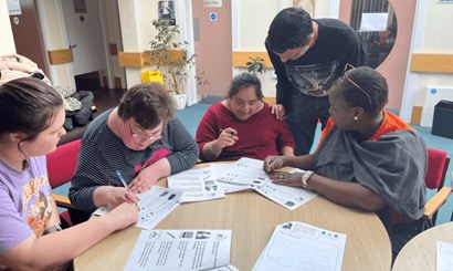 Photo of a group of service users filling out the survey forms