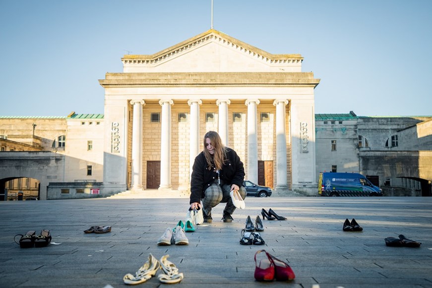 Placing shoes on floor in front of Guildhall