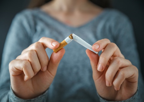 A woman snapping a cigarette in half