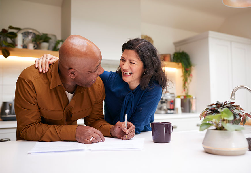 Two people doing paperwork in the kitchen