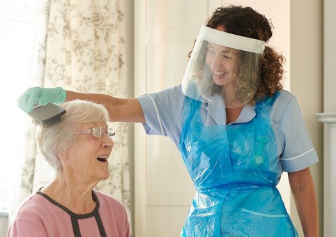 Carer brushing elderly person's hair