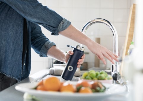 Person pouring water into a refillable water bottle