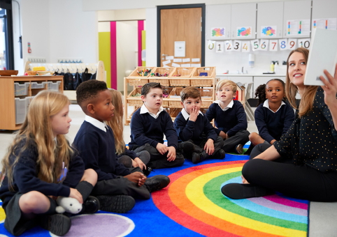 Teacher and pupils sat on rainbow form