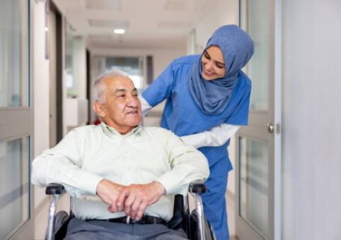 Carer and elderly man in wheelchair