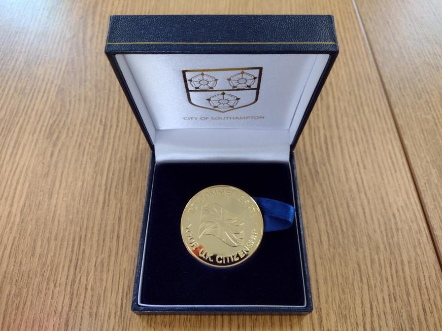 A citizenship medal in its presentation case