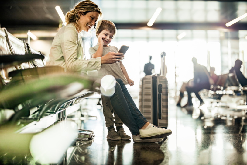 A mother and child looking happy while waiting in an airport terminal