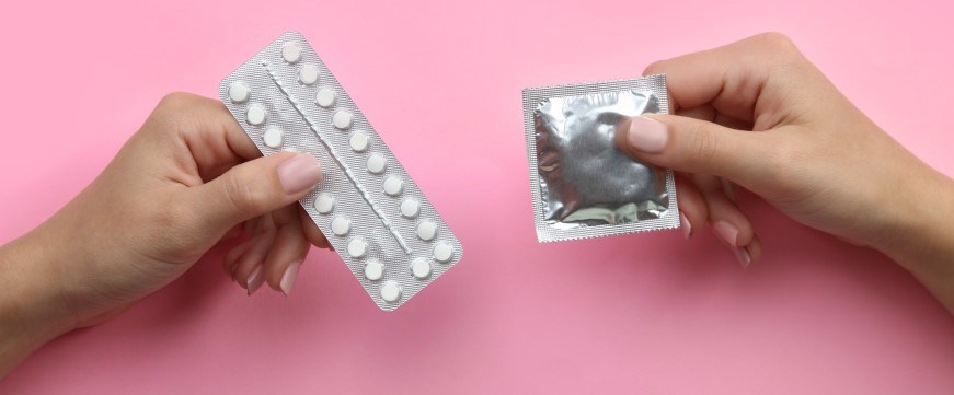 Image of someone holding contraceptive pills and a condom