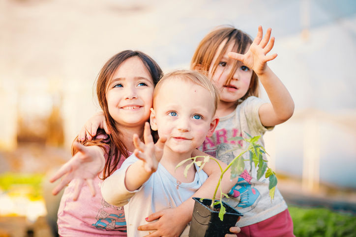 Three children reaching out 