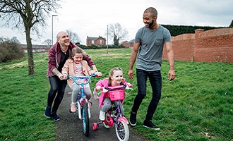 Two adults with children on bikes