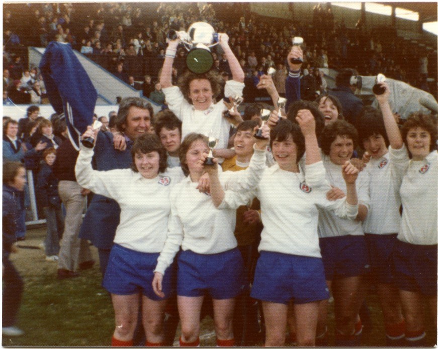 Women's football team celebrating with their trophies