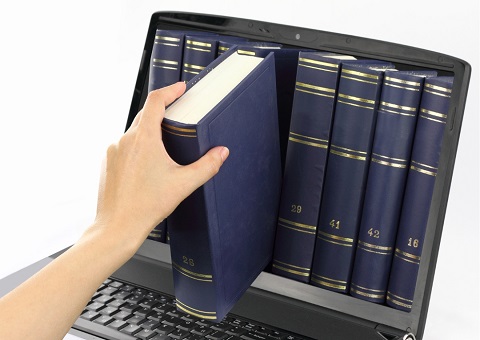 A book being pulled through a laptop screen