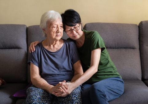 Elderly woman being comforted by daughter