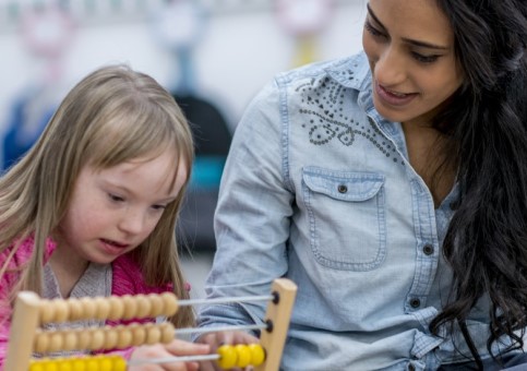 Adult with child using an abacus