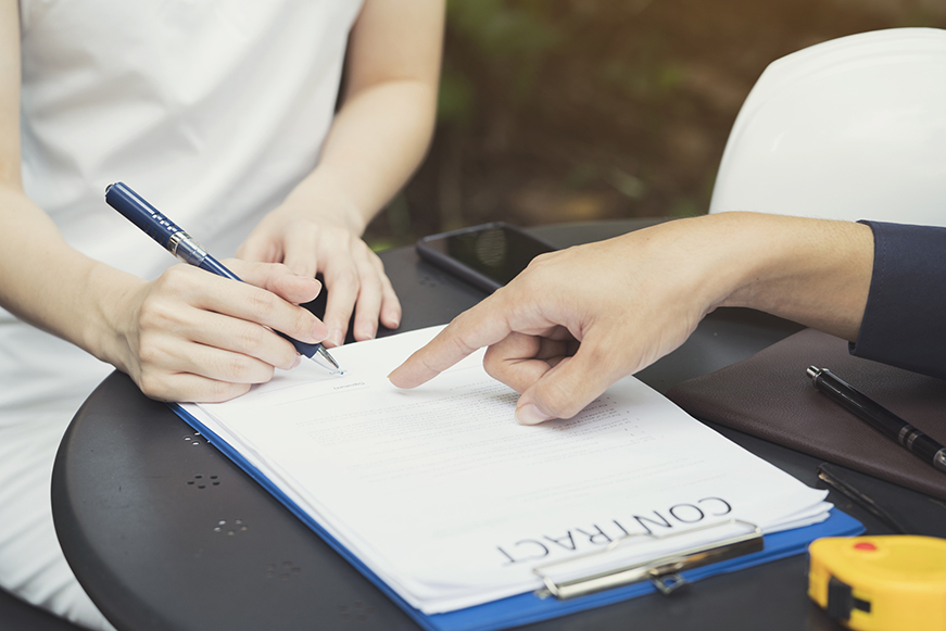 Hands Holding A Pen About To Sign A Contract