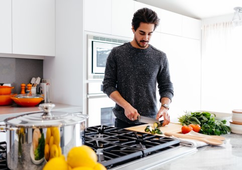 Person alone in a kitchen prepping vegetables