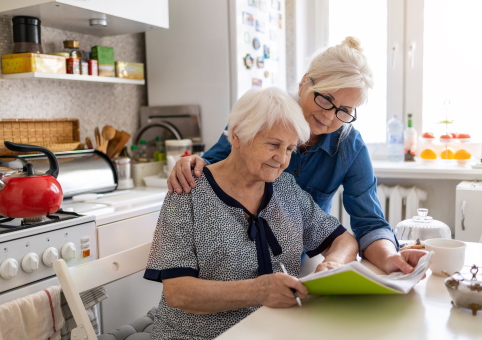Woman helping elderly woman with paperwork