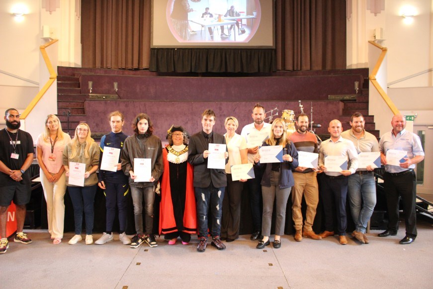 Group photo from the graduation ceremony. The mayor is present and lined by participants in the programme
