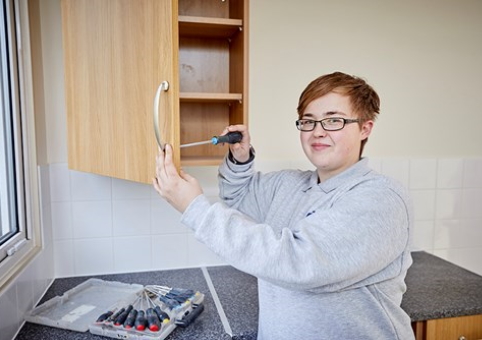 Someone fixing a cabinet door