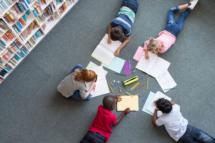 A group of children studying on a library floor