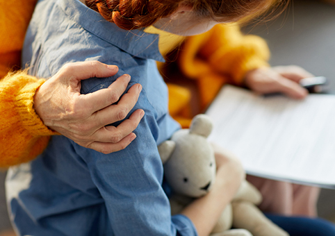 Child being held and looking at a document