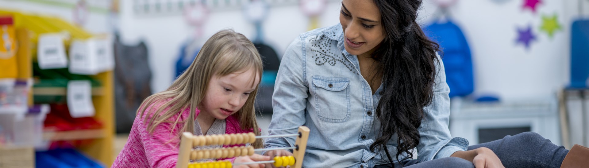 Adult with child using an abacus