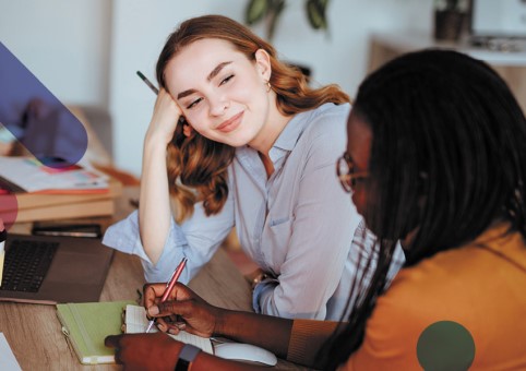 Two women talking at desk