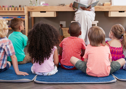 Children listing to childcare staff