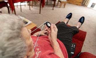 Elderly woman holding personal alarm