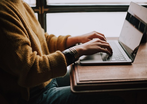 Man in jumper sitting at laptop