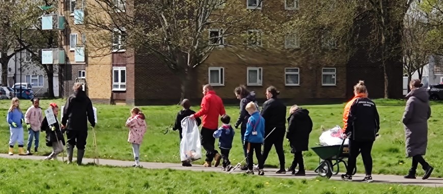 A group of children and adults walking along a path