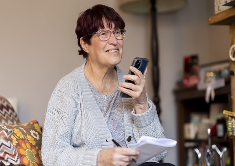 A woman at a table with paper and bills