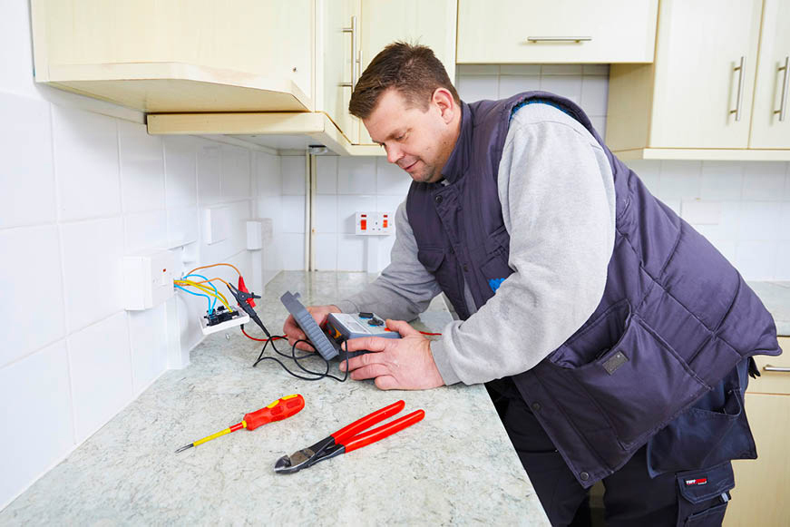 An electrician testing a wall socket An electrician testing a wall socket