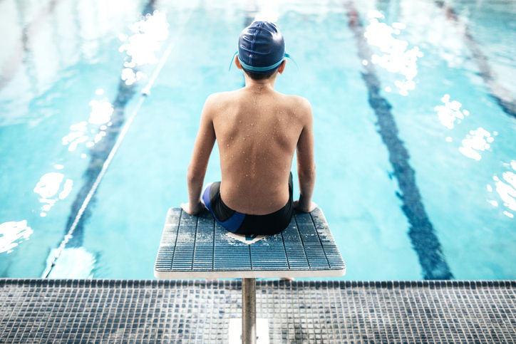 A boy about to go swimming in a pool