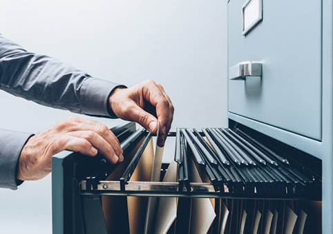 Person looking through a filing cabinet