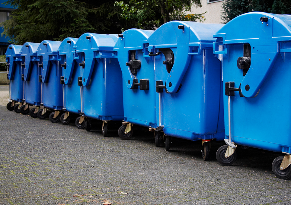 A line of large blue commercial bins