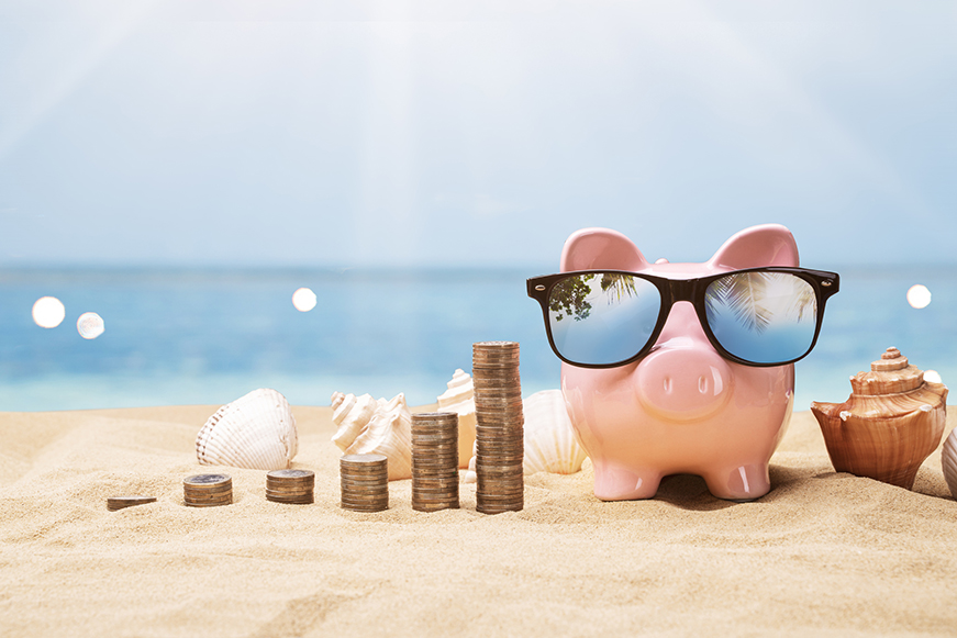 Piggy bank on the beach in sunglasses